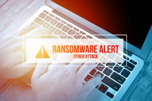 Hand Typing on keyboard with text RANSOMWARE ALERT